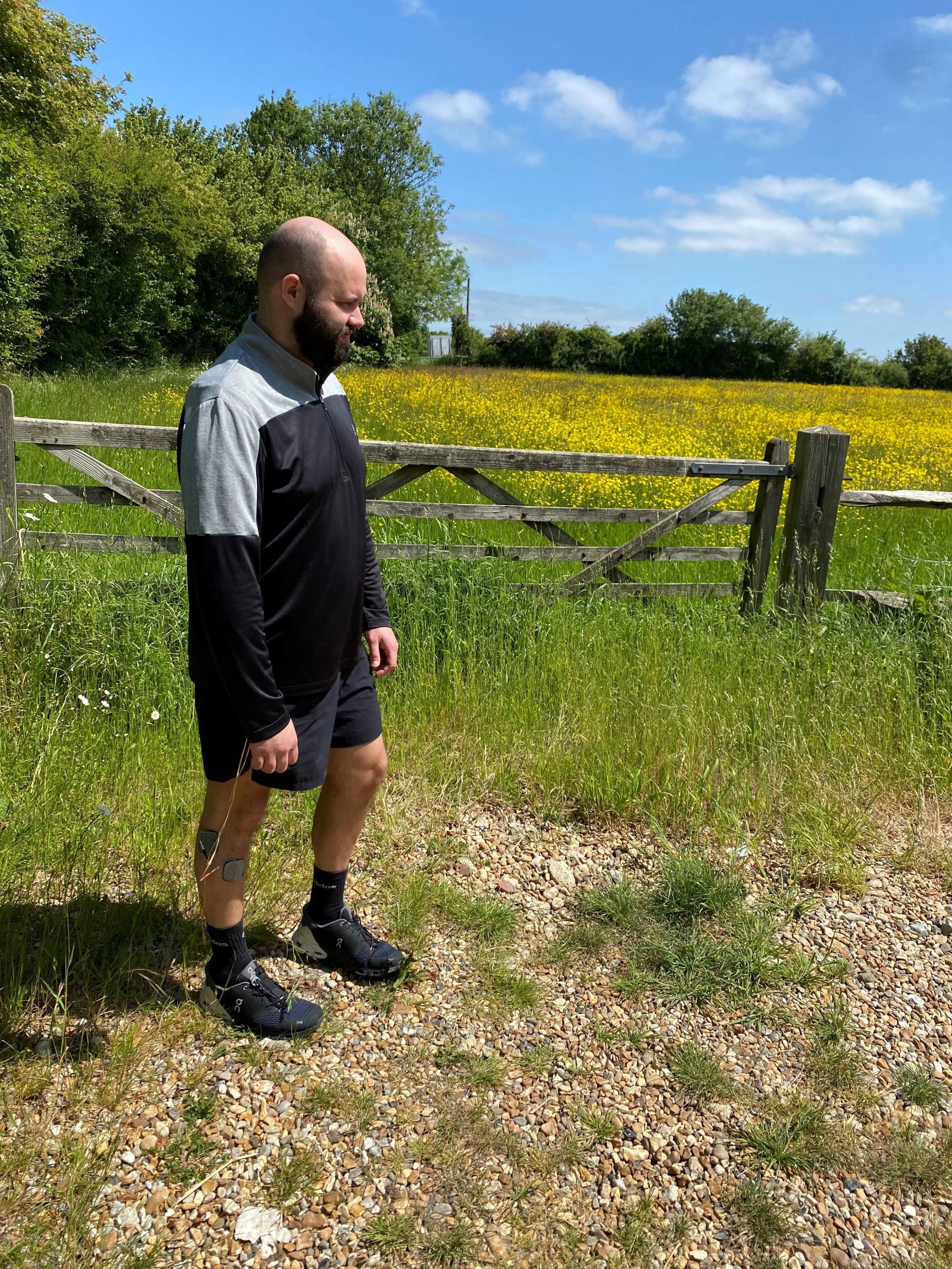Tom is stood looking out over a field of yellow flowers