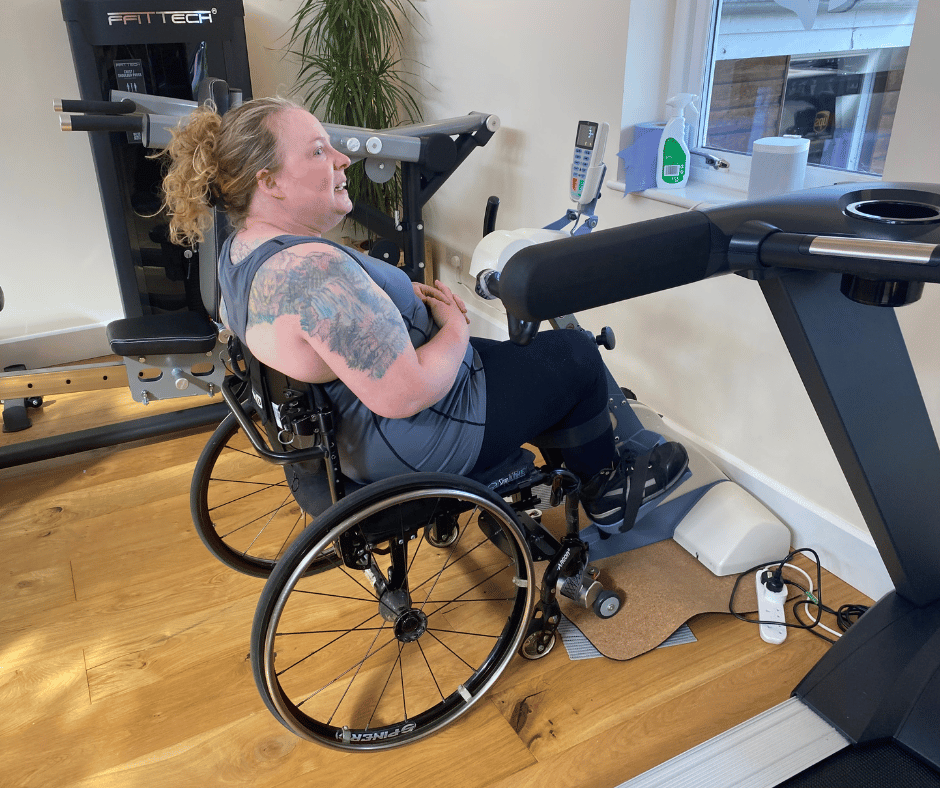Sarah Sits in her wheelchair whilst using the Thera Trainer Tigo