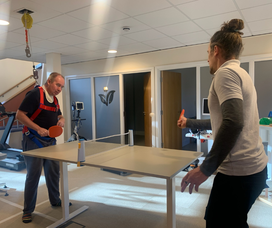 tom and piers playing table tennis whilst piers wears falls arrest