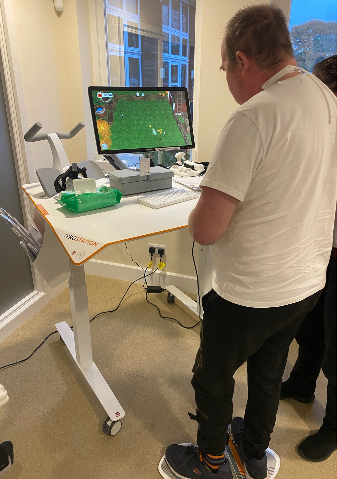 Piers is stood using the tymo whilst he plays Therapy games