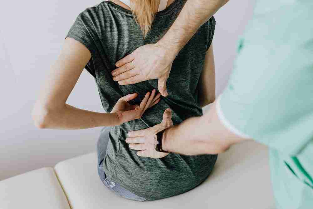 a therapist using therapeutic techniques on a womans back