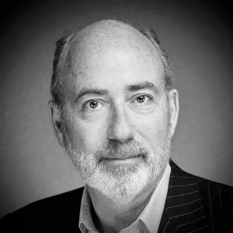 black and white headshot of Crispin Simon MBE