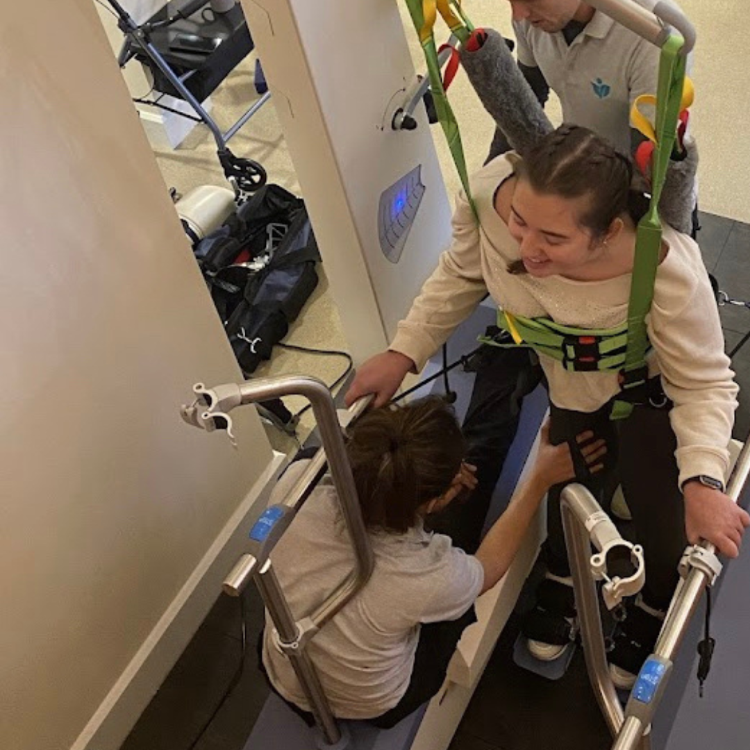 Macy is strapped into the lyra gait trainer 